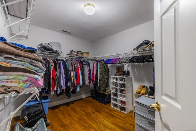 a view of walk in closet with clothes and shoes