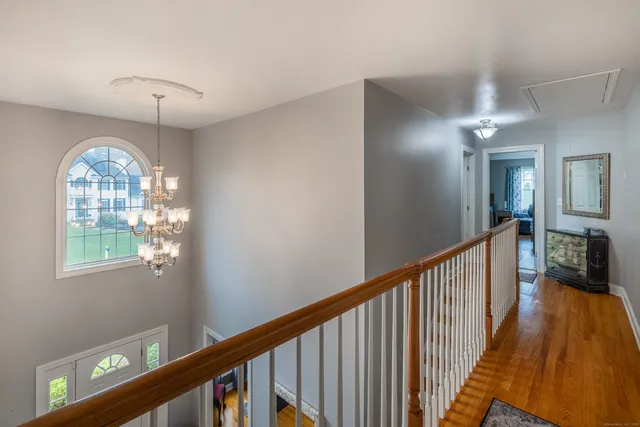a view of a hallway with windows and chandelier