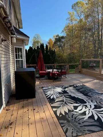 a view of a patio with table and chairs couches with wooden floor and fence