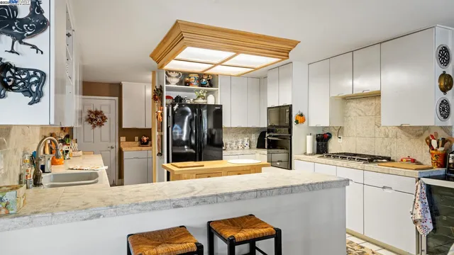 a kitchen with stainless steel appliances kitchen island granite countertop a refrigerator and a stove top oven