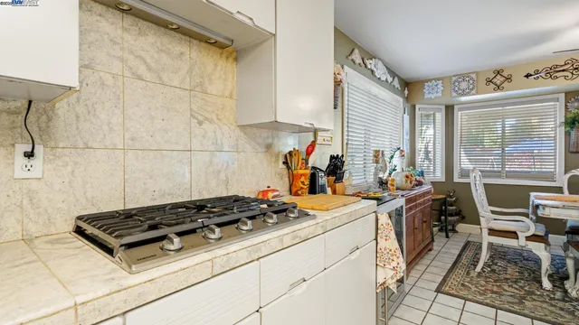a kitchen with a sink a stove and chairs