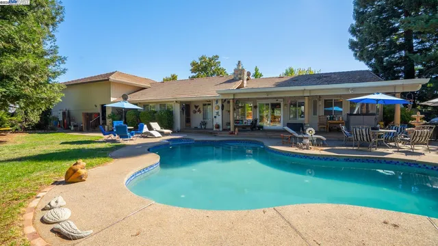 a view of a house with swimming pool and yard