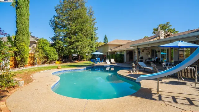 a view of backyard with swimming pool and patio