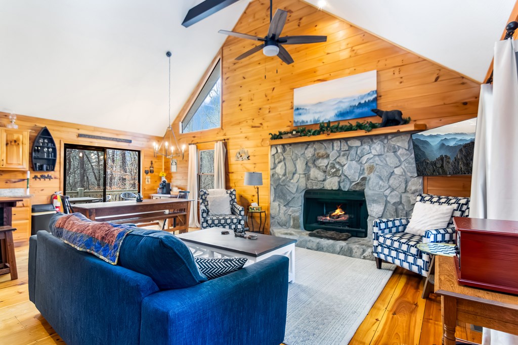 174 Seneca Way Ellijay, GA 30540 - Photo 7 of 36 a living room with furniture a fireplace and a floor to ceiling window