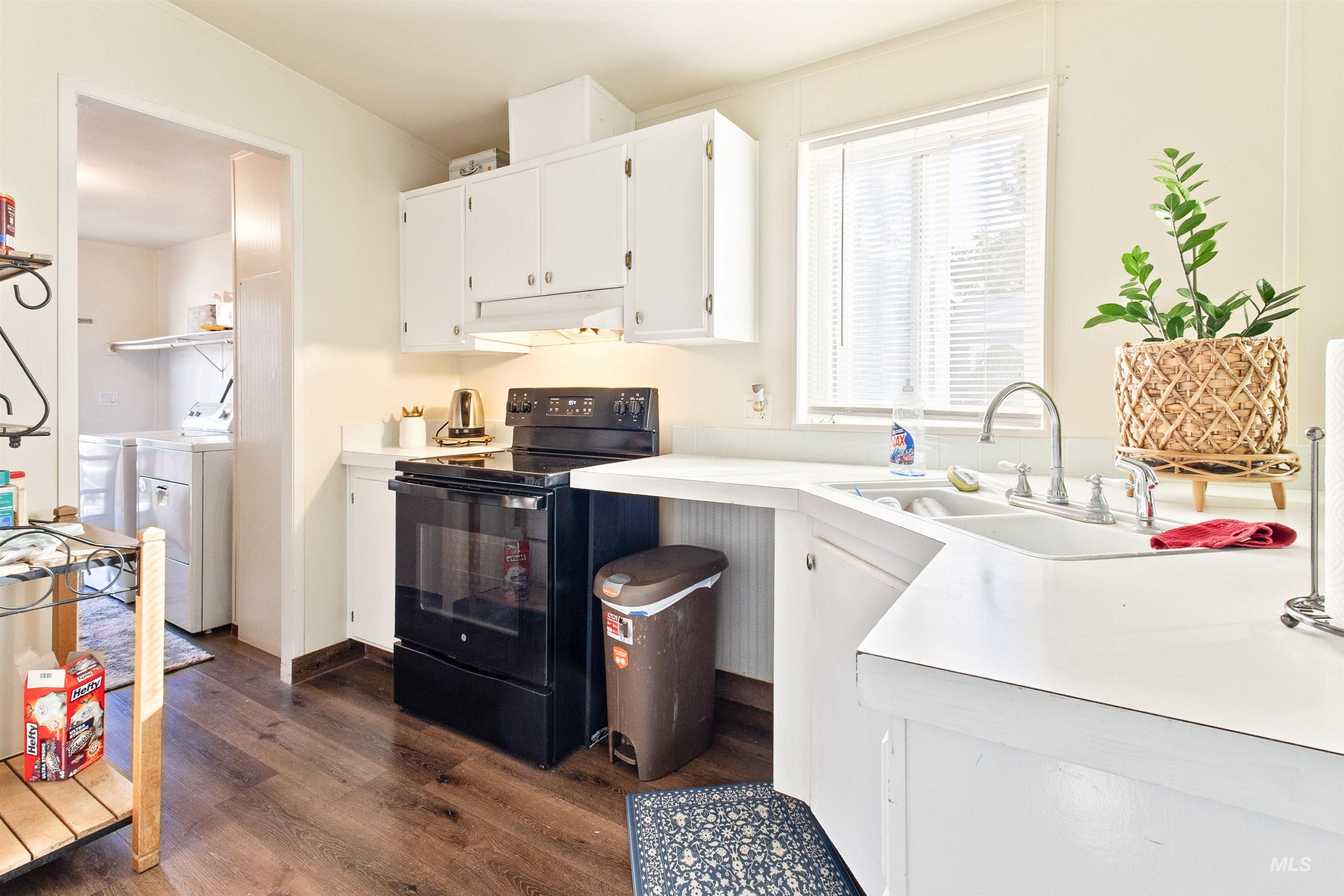 524 West Mesquite Street Boise, ID 83713 - Photo 12 of 29 Kitchen featuring white cabinets, black / electric stove, light countertops, dark wood-style floors, and under cabinet range hood