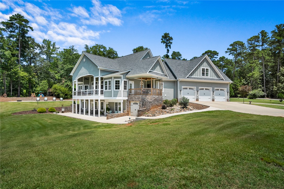 206 James Hare Road Anderson, SC 29626 - Photo 2 of 50 A spacious residence featuring multiple balconies and an attached three-car garage, nestled within a verdant landscape.