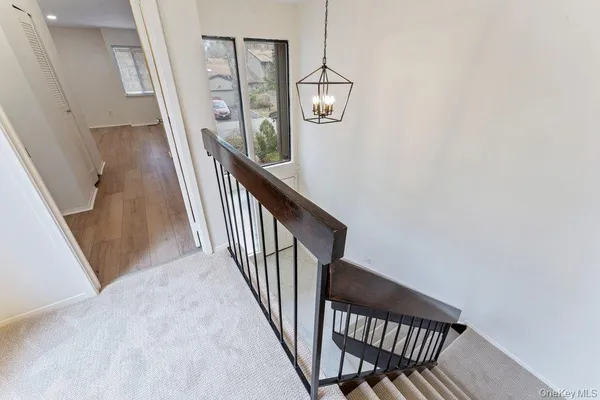 a view of a hallway with wooden floor and staircase