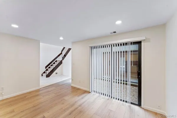 a view of a hallway with wooden floor and stairs