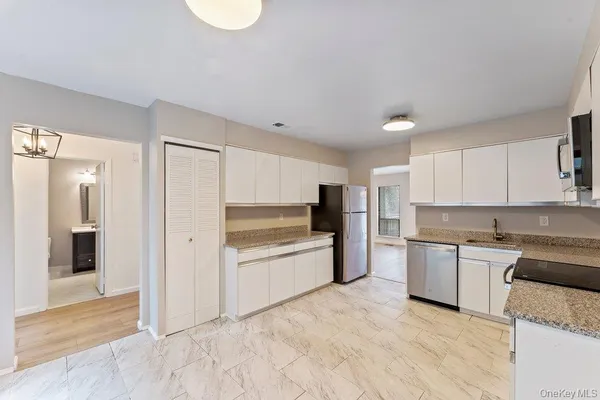 a kitchen with granite countertop a refrigerator and a sink