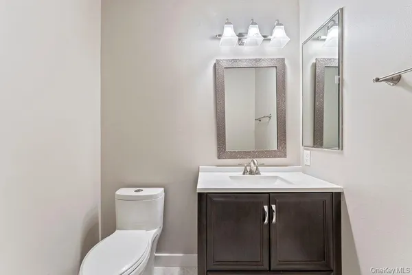 a bathroom with a sink vanity mirror and toilet
