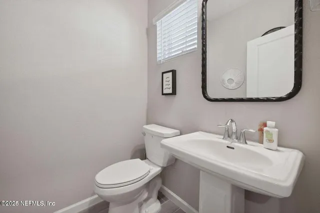 a bathroom with a toilet sink and mirror