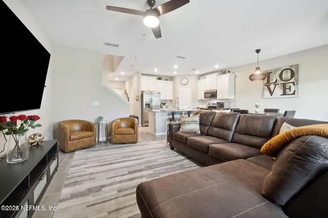 a living room with furniture kitchen view and a flat screen tv