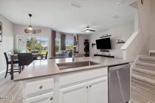 a kitchen with kitchen island granite countertop a sink a counter space appliances and cabinets