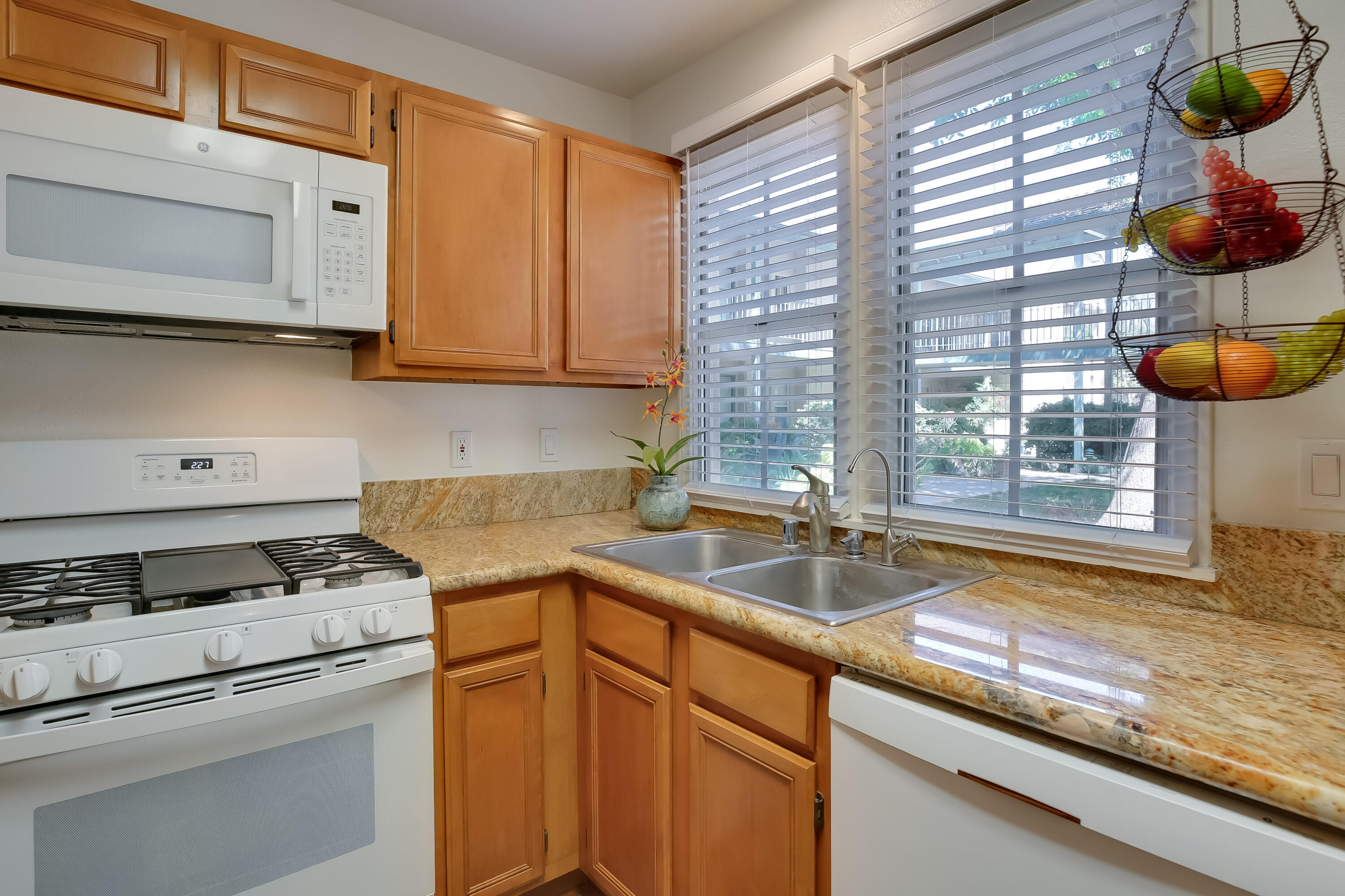 317 5th Street, Unit C Solvang, CA 93463 - Photo 8 of 24 a kitchen with granite countertop a sink a stove and cabinets