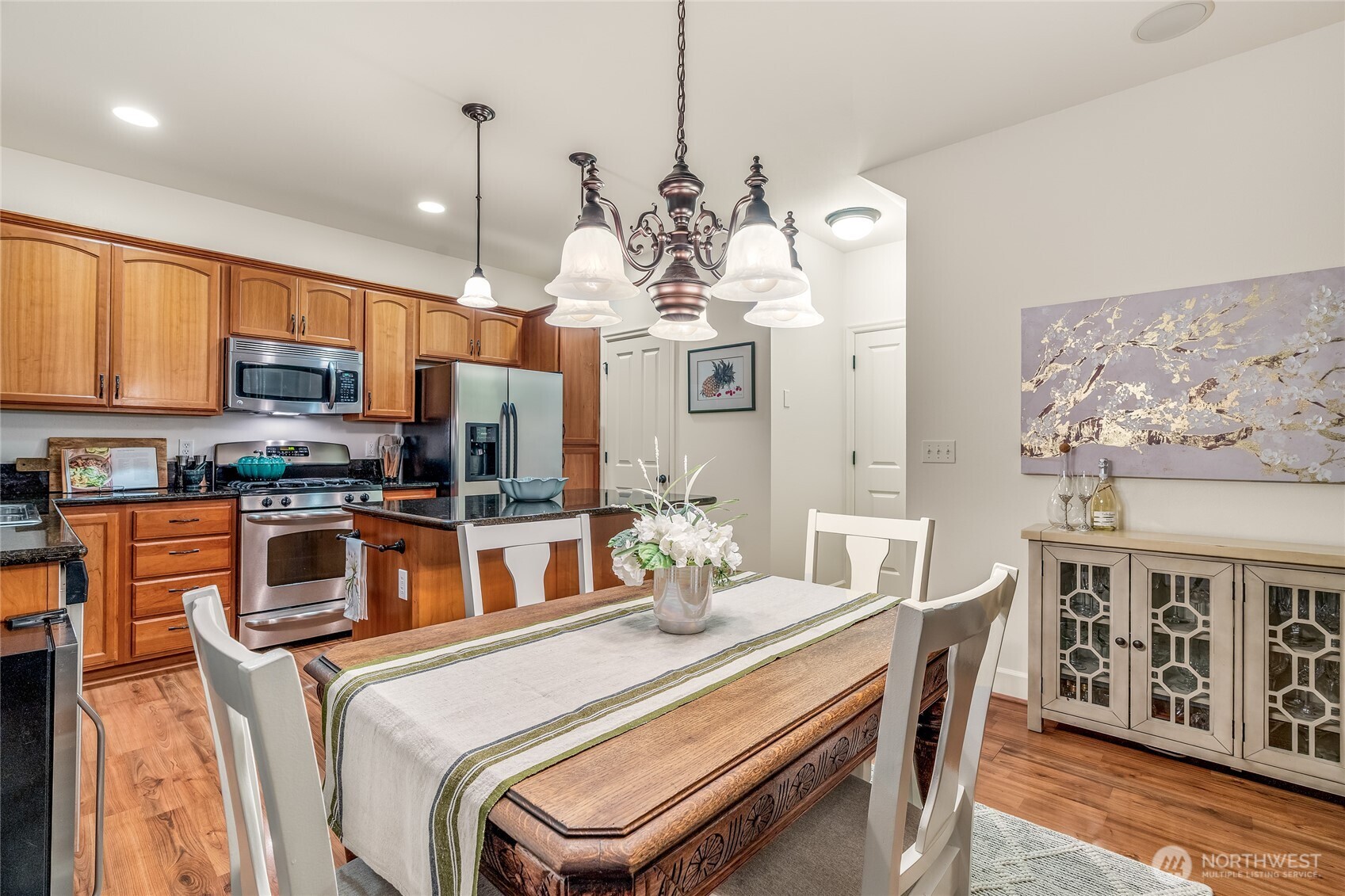 16239 2nd Place South Seattle, WA 98148 - Photo 11 of 40 a kitchen with stainless steel appliances granite countertop a stove top oven a sink a dining table and chairs with wooden floor