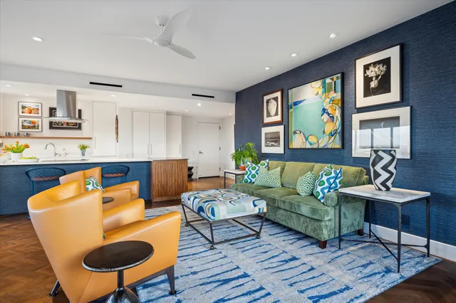 a living room with furniture kitchen view and a window