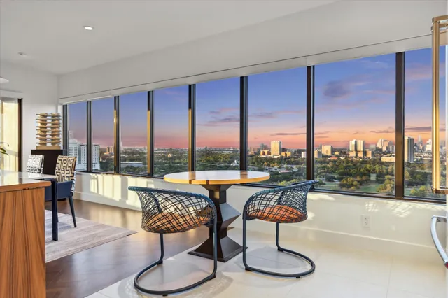 a large white kitchen with a large window and stainless steel appliances