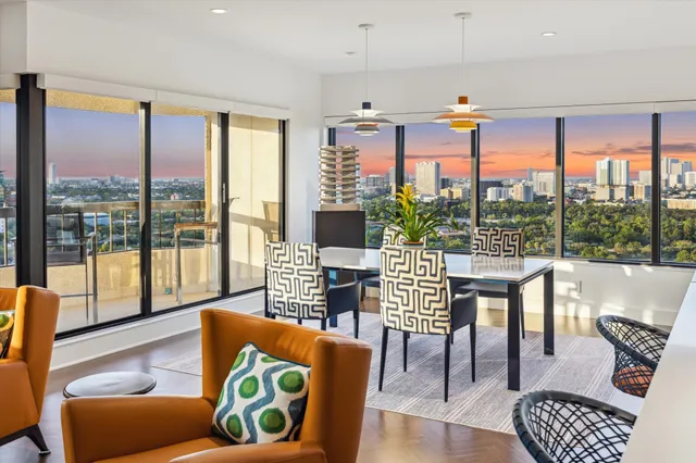 a living room with furniture and floor to ceiling windows