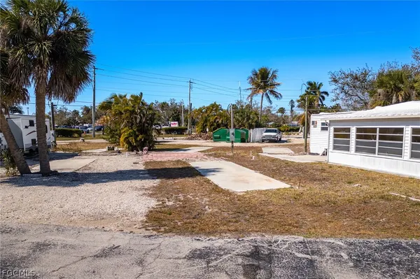 a view of a backyard with a barbeque grill and palm trees