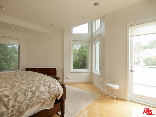 a bedroom with a bed and a large window