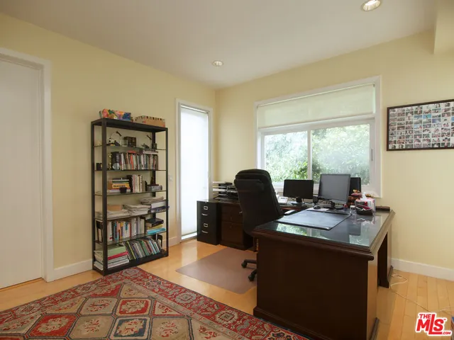 a view of a workspace with furniture and a window