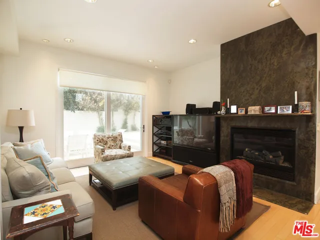 a living room with furniture a fireplace and a floor to ceiling window