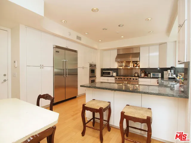 a kitchen with stainless steel appliances kitchen island granite countertop a sink and cabinets