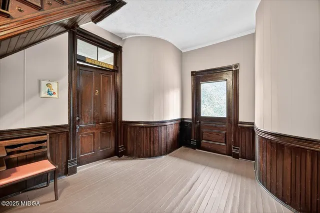 a view of an empty room with wooden floor fireplace and a window