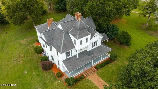 an aerial view of a house with a yard swimming pool and outdoor seating