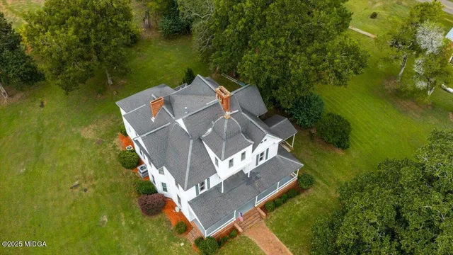 an aerial view of residential houses with outdoor space and trees