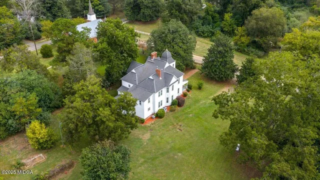 an aerial view of a house with swimming pool and garden
