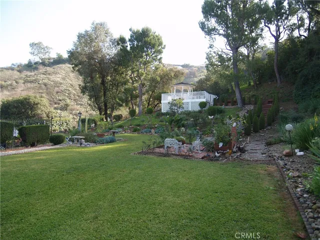 a view of a wooden house with a yard and sitting area