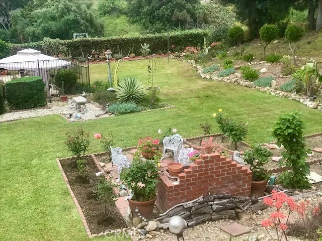 a view of a big house with a big yard plants and large trees