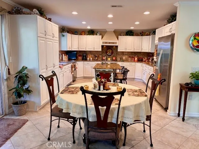 a kitchen with granite countertop a table chairs sink and cabinets