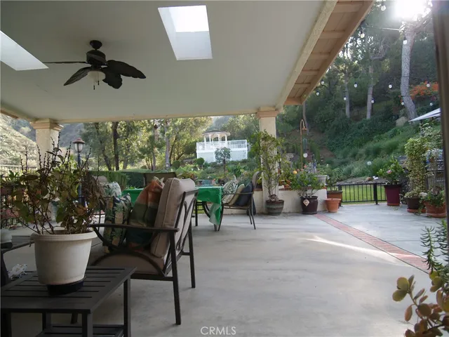 a living room with furniture kitchen view and a large window