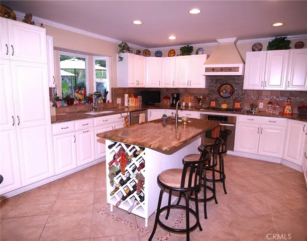 a kitchen with stainless steel appliances granite countertop a stove a sink a microwave a dining table and chairs