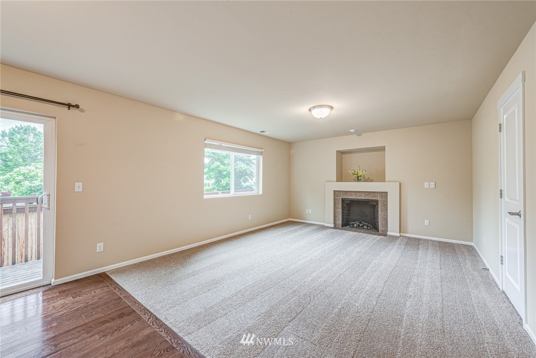919 228th Street Southeast Bothell, WA 98021 - Photo 12 of 25 an empty room with wooden floor fireplace and windows