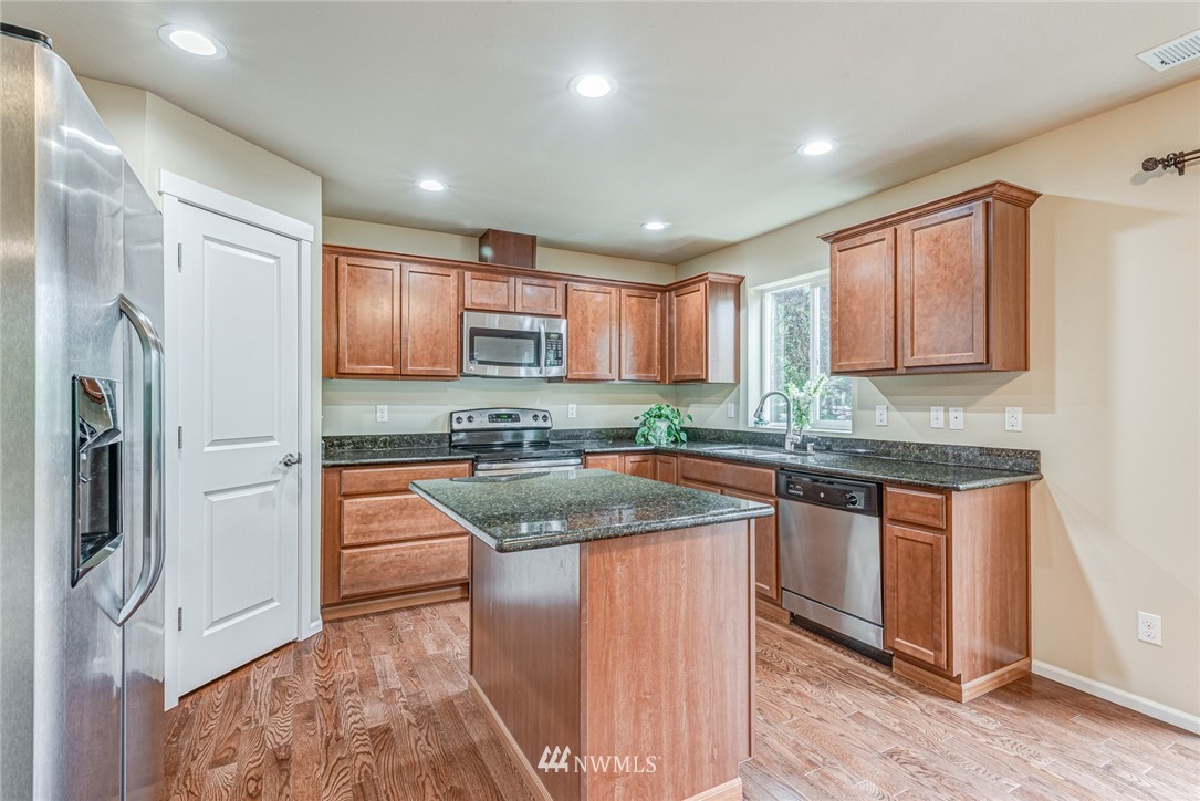 919 228th Street Southeast Bothell, WA 98021 - Photo 13 of 25 a kitchen with stainless steel appliances granite countertop a refrigerator sink and cabinets