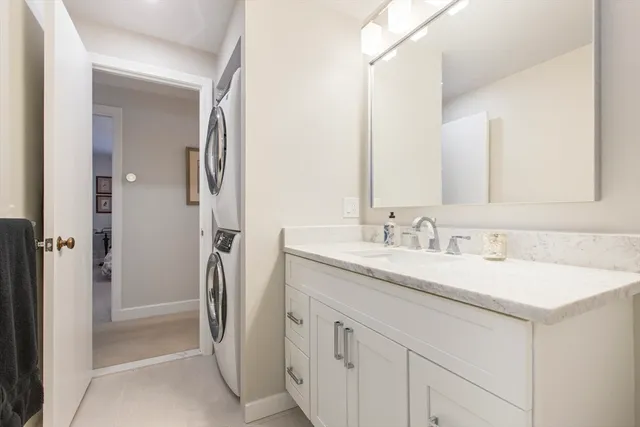 a bathroom with a granite countertop sink mirror vanity and toilet