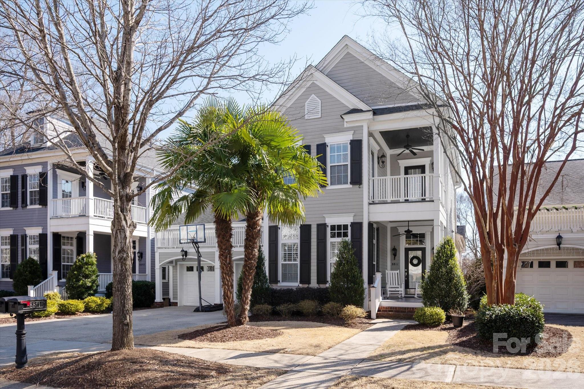a front view of a house with a tree