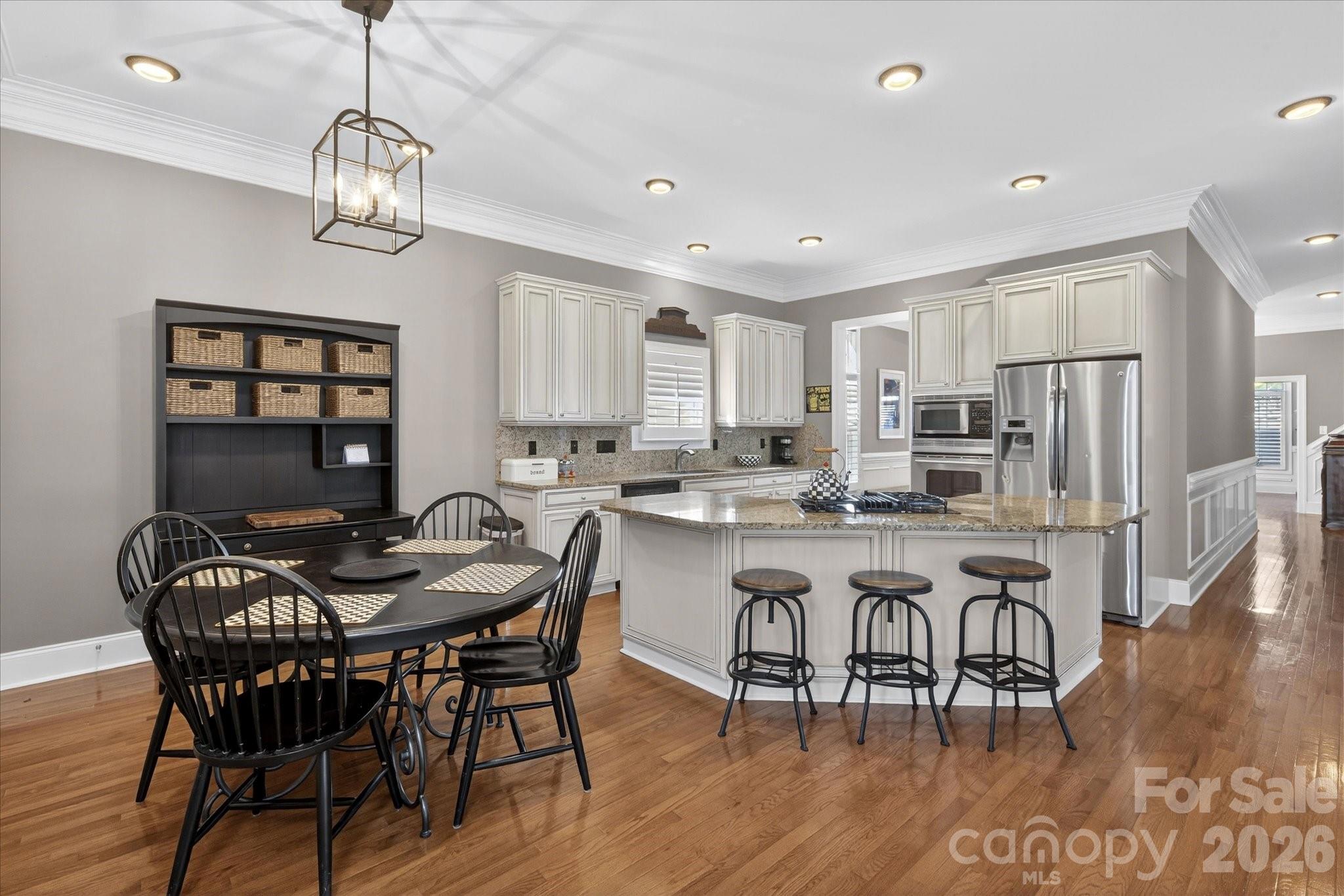 8811 1st Bloom Road Charlotte, NC 28277 - Photo 19 of 48 a kitchen with stainless steel appliances granite countertop a dining table chairs stove and refrigerator