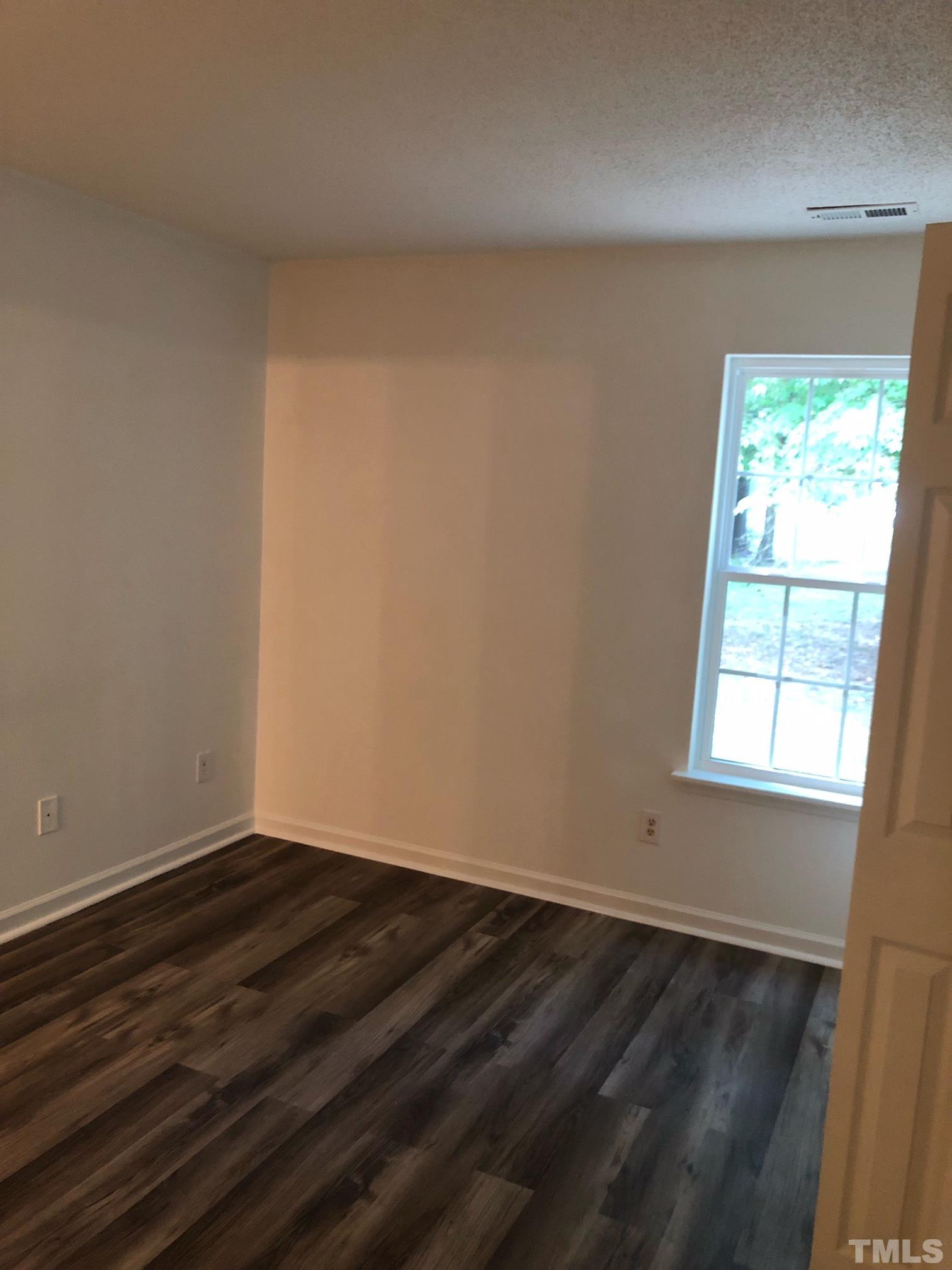 2103 Collier Road Durham, NC 27707 - Photo 13 of 23 an empty room with wooden floor and windows