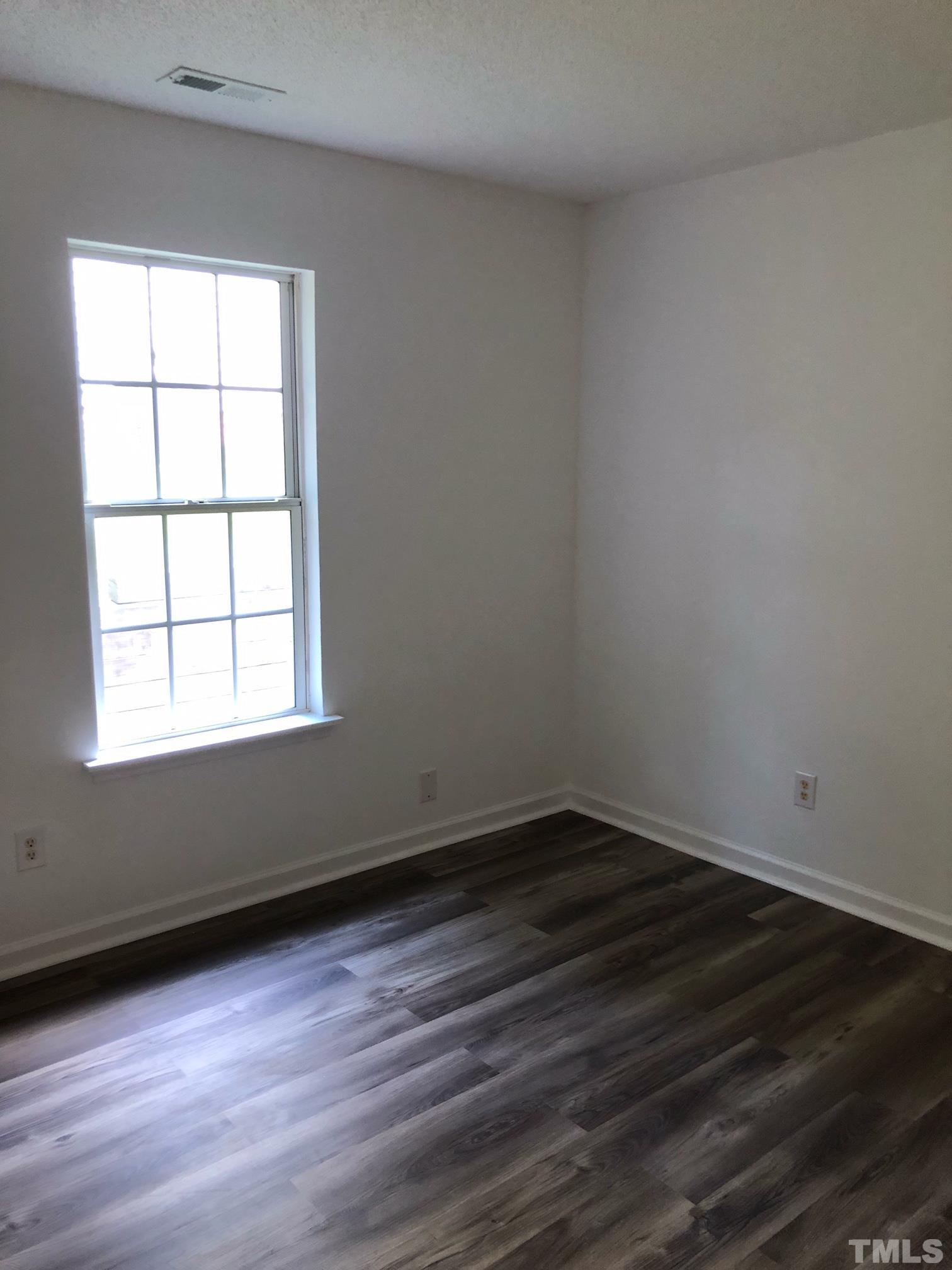 2103 Collier Road Durham, NC 27707 - Photo 15 of 23 an empty room with wooden floor and windows