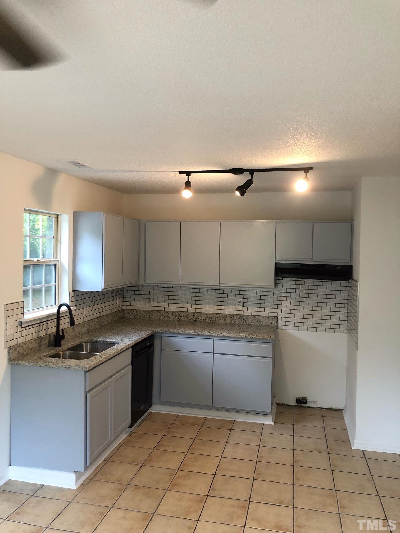 2103 Collier Road Durham, NC 27707 - Photo 3 of 23 a kitchen with a sink a counter top space cabinets and stainless steel appliances