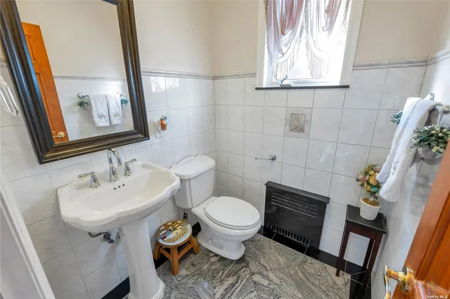 a bathroom with a toilet sink and mirror