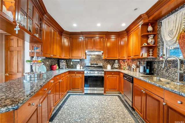 a kitchen with stainless steel appliances granite countertop a stove a sink and a microwave