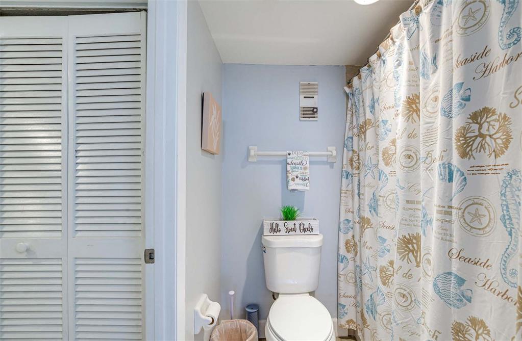 5915 Sea Ranch Drive, Unit 310 Hudson, FL 34667 - Photo 13 of 25 a white toilet sitting next to a shower curtain