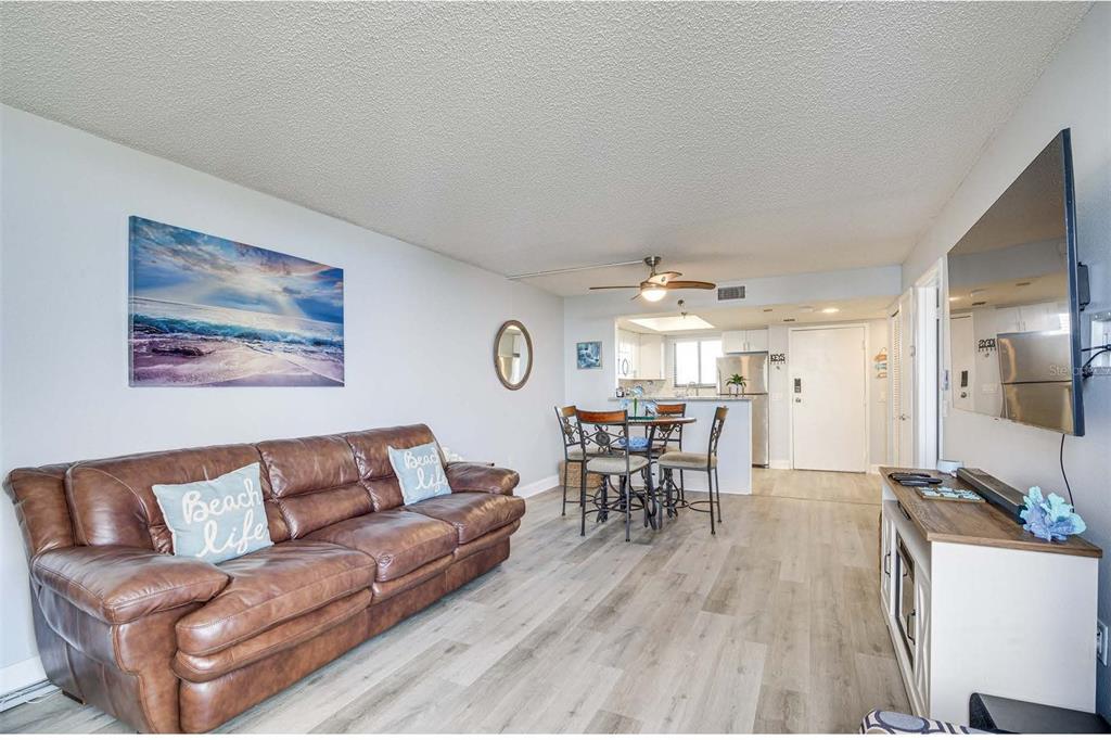 5915 Sea Ranch Drive, Unit 310 Hudson, FL 34667 - Photo 8 of 25 a living room with furniture and a dining table with wooden floor