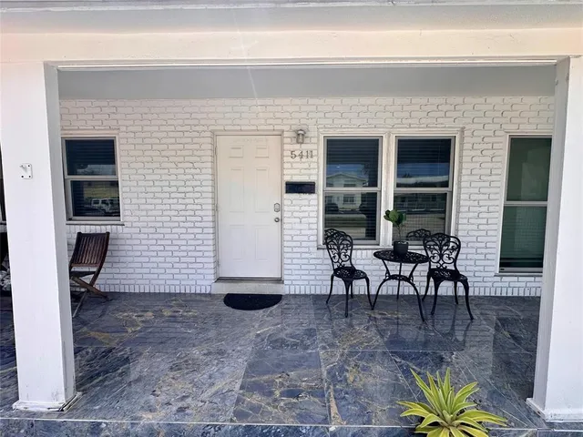 a view of a porch with dining table and chairs