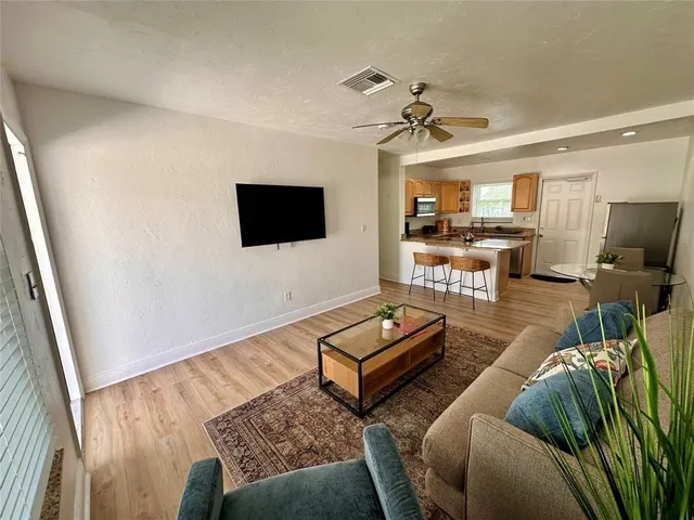 a living room with furniture a flat screen tv and kitchen view
